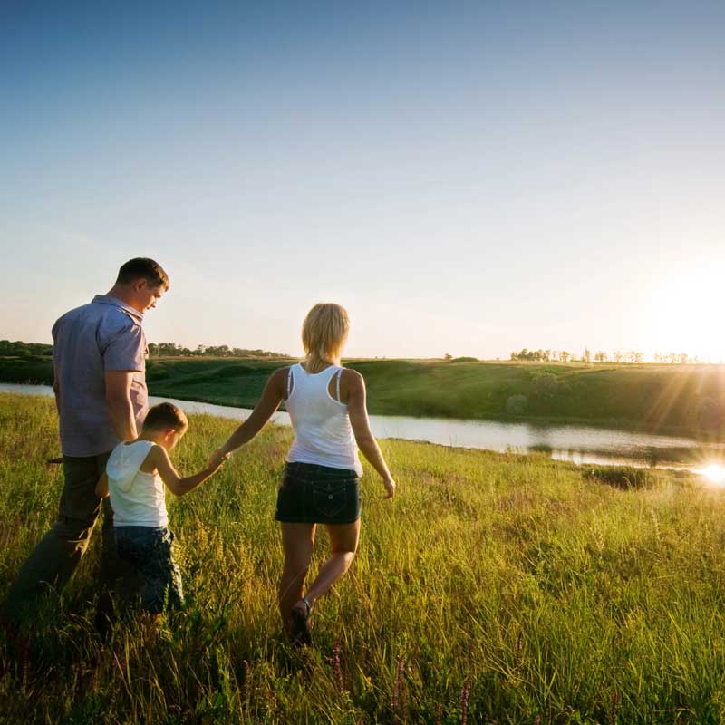 a young family walks in a field